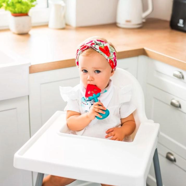BABYONO Készségfejlesztő rágóka csörgővel használatban